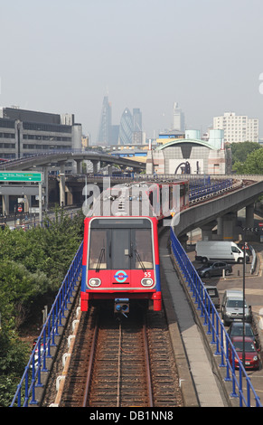 Ein London Docklands Light Railway Zug nähert Pappel-Station mit der City of London im Hintergrund Stockfoto