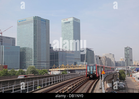 Ein London Docklands Light Railway Zug nähert Blackwall Station. Canary Wharf Geschäftsviertel im Hintergrund Stockfoto