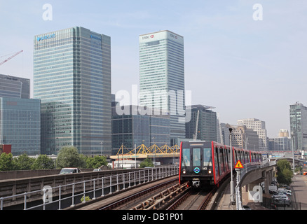 Ein London Docklands Light Railway Zug nähert Blackwall Station. Canary Wharf Geschäftsviertel im Hintergrund Stockfoto