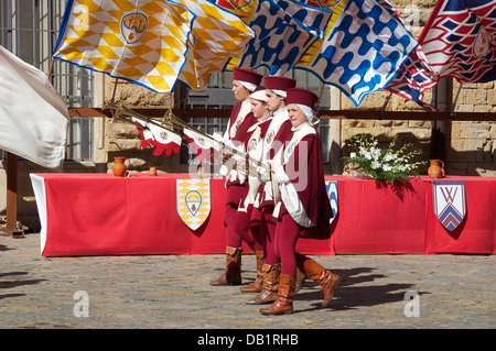 Vier Mädchen, die mit Trompeten in mittelalterlichen Festzug Volterra Toskana Italien Stockfoto