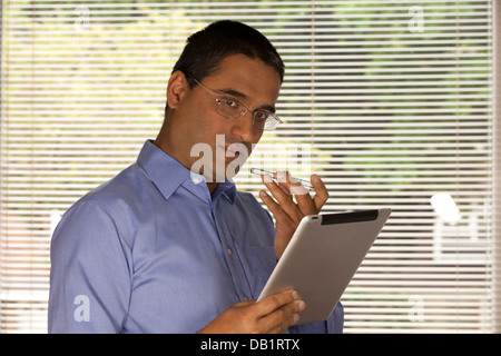 Mann am Telefon hält ipad Stockfoto