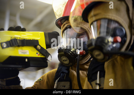 Rumpf-Wartungstechniker 3. Klasse Timothy Dunkel verwendet eine Wärmebildkamera während eine Brandbekämpfung Bohrer an Bord der amphibischen ein Stockfoto