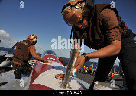 Elektroniker /-in Luftfahrt 3. Klasse Maurice Brown, von Eugene, Oregon/USA, rechts, wäscht die Oberfläche einer F/A-18F Superhornet Stockfoto