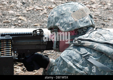 Messing und Gürtel-Clips kick Staub wie Sgt. Michael T. Crawford ein Maschinengewehr M249 während der Einarbeitung Ausbildung an Fort feuert Stockfoto