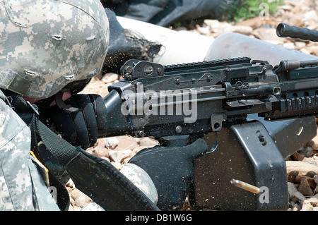 Messing und Gürtel-Clips kick Staub wie Sgt. Michael T. Crawford ein Maschinengewehr M249 während der Einarbeitung Ausbildung an Fort feuert Stockfoto