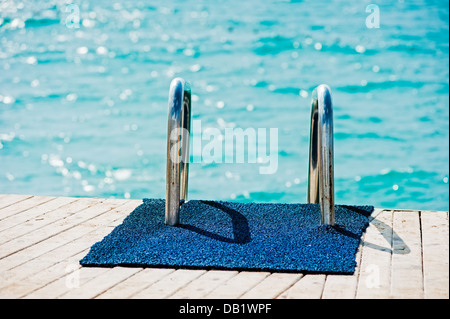 Geländer-Leiter hinunter zum Pier ins Meer. Stockfoto