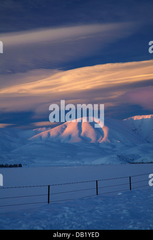 Alpenglühen am Hawkdun Range und linsenförmige Wolken, Maniototo, Central Otago, Südinsel, Neuseeland Stockfoto