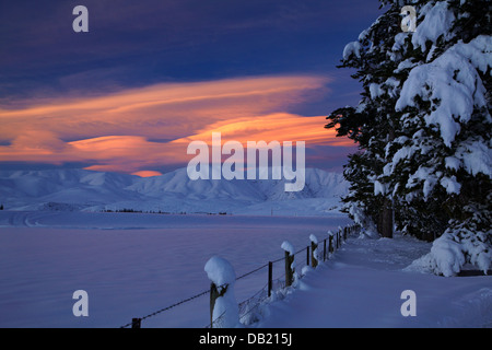 Sonnenuntergang über Hawkdun Bereich und verschneiten Ackerland in der Nähe von Oturehua, Maniototo, Central Otago, Südinsel, Neuseeland Stockfoto