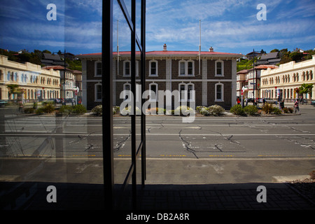 Historisches Hotel in Port Chalmers und Rathaus (rechts), spiegelt sich in Port of Otago Gebäude, Port Chalmers, Dunedin, Neuseeland Stockfoto