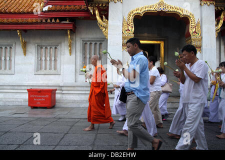 Bangkok, Thailand. 22. Juli 2013. Buddhistische Mönche führen Diener in eine Circumambulation des Wat Benchamabophit Tempel gefeiert Asalha Puja. Asalha Puja ist ein Theravada-Buddhismus-Festival, das in der Regel im Juli, auf den Vollmond des achten Mondmonats stattfindet. Bildnachweis: John Vincent/Alamy Live-Nachrichten Stockfoto