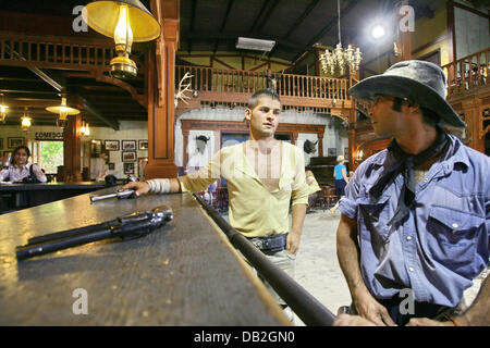 Stuntmen Julio Cortez (L) und Rafael "Taco" Aparicio sind eine Limousine abgebildet für Touristen in Westernstil Filmstadt "Fort Bravo" in der Nähe von Tabernas, Spanien, 8. Oktober 2007 durchführen. Italienische Regisseur Sergio Leone baute die Stadt in den 1960er Jahren selbst von mexikanischen und texanischen Stilen zu orientieren. Viele berühmte western-Filme wurden beschossen Fort Bravo, wie "Lawrence von Arabien" oder Stockfoto