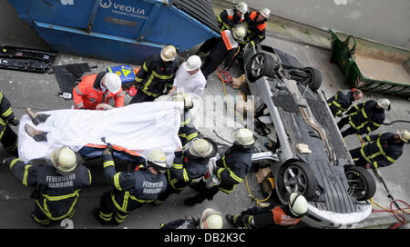 Feuerwehrleute arbeiten auf dem Gelände des Unfalls wo das Auto od eine Frau ist nach einem Sturz 10 Meter von einem Parkplatz in Hamburg, Deutschland, 14. September 2011 gelandet. Die 66-jährige Fahrerin hatte durch eine 80 Zentimeter hohe Betonwand stürzte und wurde schwer verletzt. Die Polizei weiß nicht, aber was hatte den Unfall verursacht. Foto: CHRISTIAN TIMMANN Stockfoto