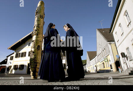 (DATEI) Eine Archivfoto vom 16. April 2007 zeigt zwei Nonnen stehen neben der Benedict-Spalte vor dem Geburtshaus von Papst Benedict XVI in Marktl am Inn, Deutschland. Sechs Jahre nach Joseph Ratzingers Ernennung zum Papst, ist Geschäft mit dem prominenten Sohn des Marklt bescheiden. Stattdessen will das Dorf auf den Glauben weitergeben. Foto: Andreas Gebert Stockfoto