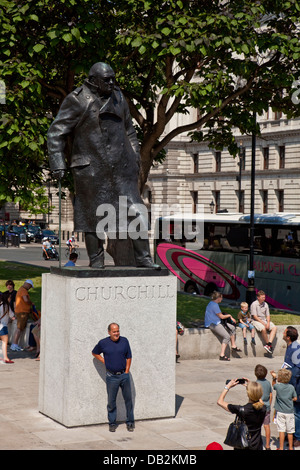 Touristen posieren vor der Winston Churchill Statue, Parliament Square, London, England Stockfoto