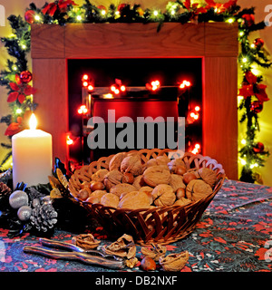 Korb mit Walnüsse und Haselnüsse mit einer Kerze und einem Kamin nach hinten, England, Großbritannien, Westeuropa. Stockfoto