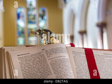 Konzept-Bild der Bibel ruhen auf der Lesung Adler Rednerpult mit Glasfenstern im Hintergrund. Stockfoto