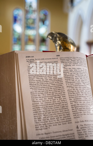 Konzept-Bild der Bibel nach Johannes 3,16, ruht auf der Lesung offen Adler Rednerpult mit Glasfenstern im Hintergrund. Stockfoto