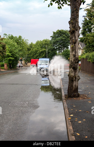 Van durch Pfütze auf der Straße fahren. Stockfoto