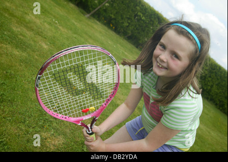 Sommer Wimbledon Tennis Fehler als junge weibliche Kind Praktiken Tennis im eigenen Garten auf dem Rasen Stockfoto
