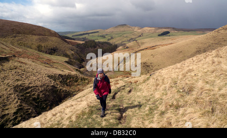 Weibliche Walker im Winter Kleidung zu Fuß bergauf in Richtung der Katze & Geige Pub, Peak District, Cheshire.  Shutlingsloe hinter. Stockfoto