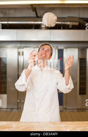 Bäcker werfen Teig in die Luft in der Bäckerei Stockfoto