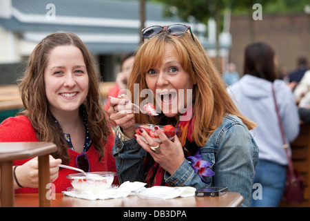 Sally Pickin (links) und Charlotte Rushworth (rechts) genießen Sie Erdbeeren und Sahne auf Tee Rasen The Championships Wimbledon 201 Stockfoto