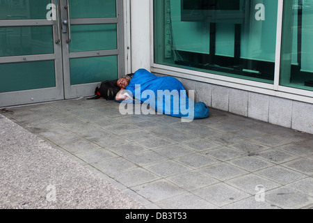 Ein Obdachloser Mann im Bild der Straße in einem Hauseingang in Brighton und Hove, East Sussex, UK. Stockfoto