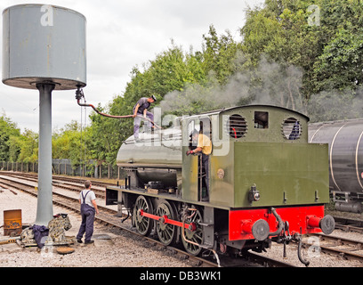 Lokführer unter Wasser vom Wasserturm an Preston Dampfeisenbahn, Preston mit Dampf. Stockfoto