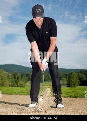 Senioren Golf spielen, in schwarz gekleidet. Aktion im Bunker erschossen. Stockfoto