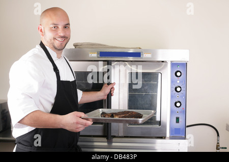 Happy Chef nimmt seine frisch gebackenes Rib-Eye steak Stockfoto