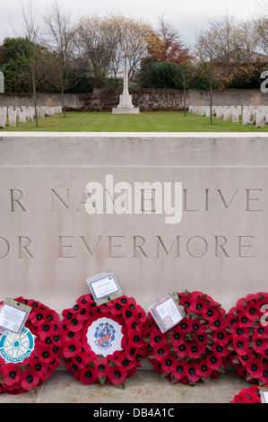 Kreuz, kriegsgräberfürsorge & Runder roter Mohn Kränze auf Stein der Erinnerung nach der Zeremonie - Stonefall Friedhof, Harrogate, North Yorkshire, England, UK. Stockfoto