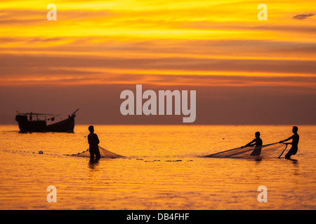 Fischer ziehen in einem Fischernetz von hand manuell bei Sonnenuntergang am Strand von Kuakata, Distrikt Patuakhali in Süd-west-Bangladesch Stockfoto