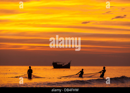 Fischer werfen die letzte Netz bei Sonnenuntergang in der Bucht von Bengalen am Kuakata Beach in Patuakhali Bezirk von Bangladesh. Stockfoto