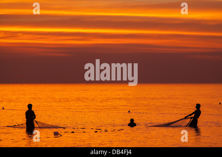 Fischer werfen die letzte Netz bei Sonnenuntergang in der Bucht von Bengalen am Kuakata Beach in Patuakhali Bezirk von Bangladesh. Stockfoto