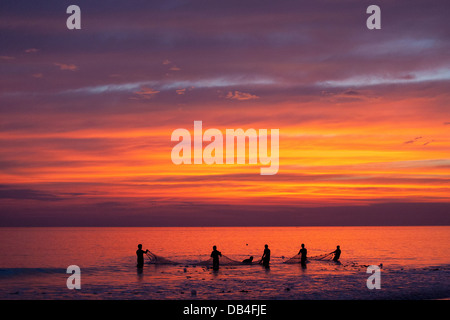 Fischer werfen die letzte Netz bei Sonnenuntergang in der Bucht von Bengalen am Kuakata Beach in Patuakhali Bezirk von Bangladesh. Stockfoto