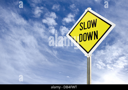 Slow Down gelbe Verkehrszeichen auf blauen Himmel mit Wolken-Hintergrund Stockfoto