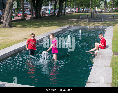 Kinder erfrischen Sie sich im Wasser-Funktion in Southport Park während Sommer Hitzewelle, North West England, UK Stockfoto