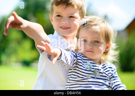 Kleinen Bruder und Schwester spielen im Garten