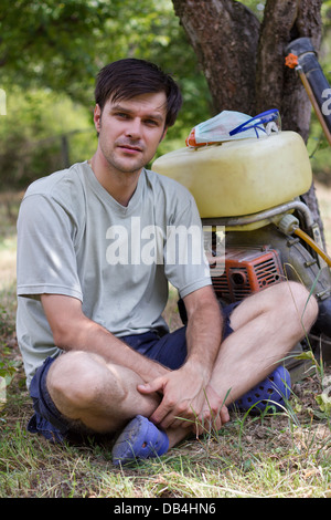 Landwirt in seinem Obstgarten mit einem Sprühgerät Stockfoto