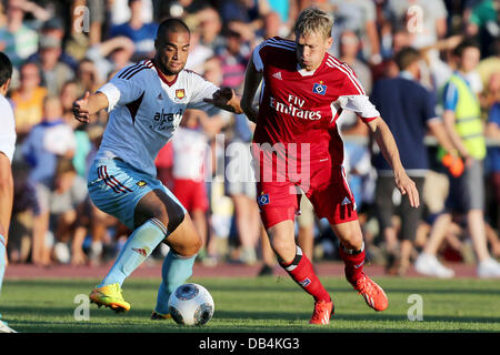 Flensburg, Deutschland. 23. Juli 2013. Uniteds Winston Reid (L) wetteifert um den Ball mit Hamburgs Artjoms Rudnevs während der Fußball-Testspiel zwischen dem Hamburger SV und West Ham United im Stadion Arndstrasse in Flensburg, Deutschland, 23. Juli 2013. Foto: Malte Christen/Dpa/Alamy Live News Stockfoto