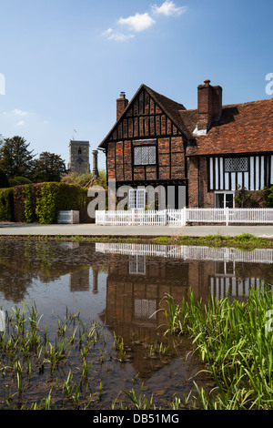 Teilansicht eines Backstein und Fachwerk-Herrenhaus, mit Blick auf den Dorfteich Ente in Aldbury, Hertfordshire, England Stockfoto