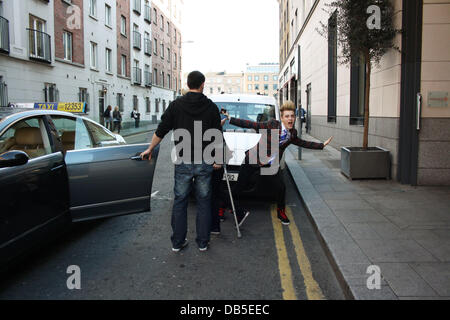 Irische Eurovision Hoffnungsträger Jedward aka John Grimes und Edward Grimes (Edward auf Krücken) verlassen Dublins Morrison Hotel nach einem Treffen mit berühmten Designer Louis Copeland Kleidung. Als sie ankamen Copeland trafen sich mit den Jungs und alle 3 verschwand ein p Stockfoto