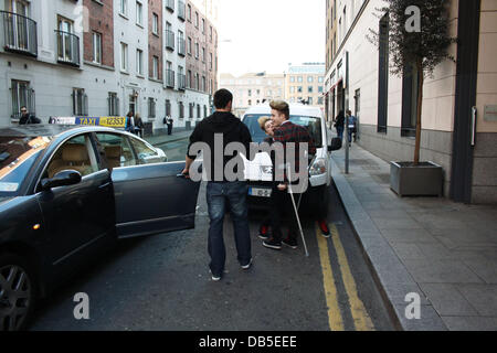 Irische Eurovision Hoffnungsträger Jedward aka John Grimes und Edward Grimes (Edward auf Krücken) verlassen Dublins Morrison Hotel nach einem Treffen mit berühmten Designer Louis Copeland Kleidung. Als sie ankamen Copeland trafen sich mit den Jungs und alle 3 verschwand ein p Stockfoto