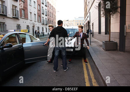 Irische Eurovision Hoffnungsträger Jedward aka John Grimes und Edward Grimes (Edward auf Krücken) verlassen Dublins Morrison Hotel nach einem Treffen mit berühmten Designer Louis Copeland Kleidung. Als sie ankamen Copeland trafen sich mit den Jungs und alle 3 verschwand ein p Stockfoto