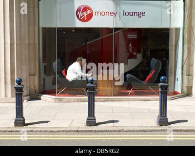 Mann auf dem Handy sitzen in Virgin Geld Lounge, Manchester UK Stockfoto
