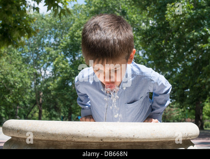 Kind Trinkwasser aus einem Brunnen. Nahaufnahme Stockfoto