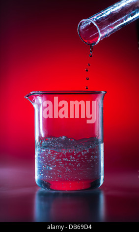 Becherglas im Labor gießt flüssige Chemikalien in Becher Stockfoto