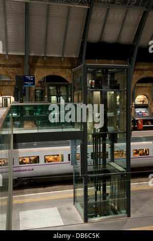 Glaslift im Bereich Plattform des Kings Cross Railway Station, London, England, mit Ostküste Zug zu fahren. Stockfoto