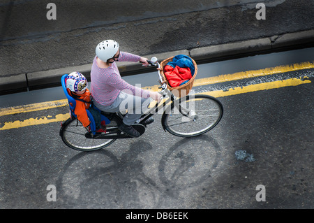 Eine Frau mit einem Kind in den Kindersitz Fahrrad Fahrrad Stockfoto