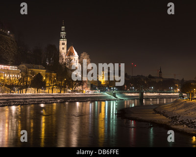 Reflexionen über die Salzach-Winter. Die Lichter der beleuchtete Salzburg spiegeln in einer Kurve im Schnee Querneigung Fluss. Stockfoto